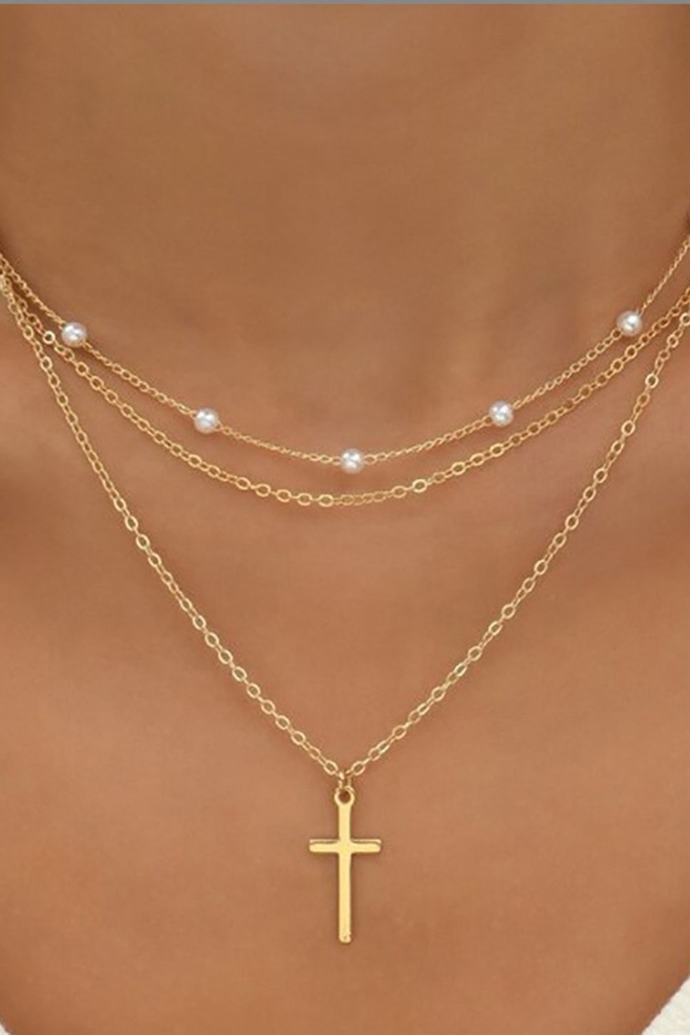 Gold plated cross pendant with pearl decor on triple layer chain necklace
