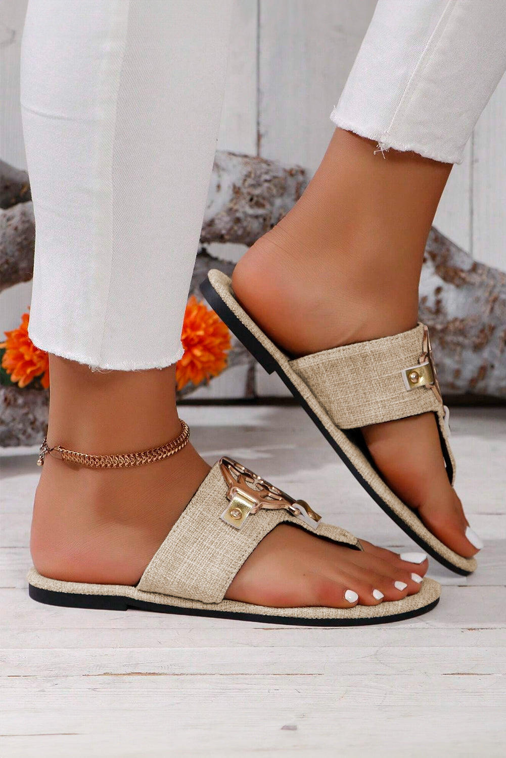 Beige leather thong slippers with stylish metal decor and adjustable straps