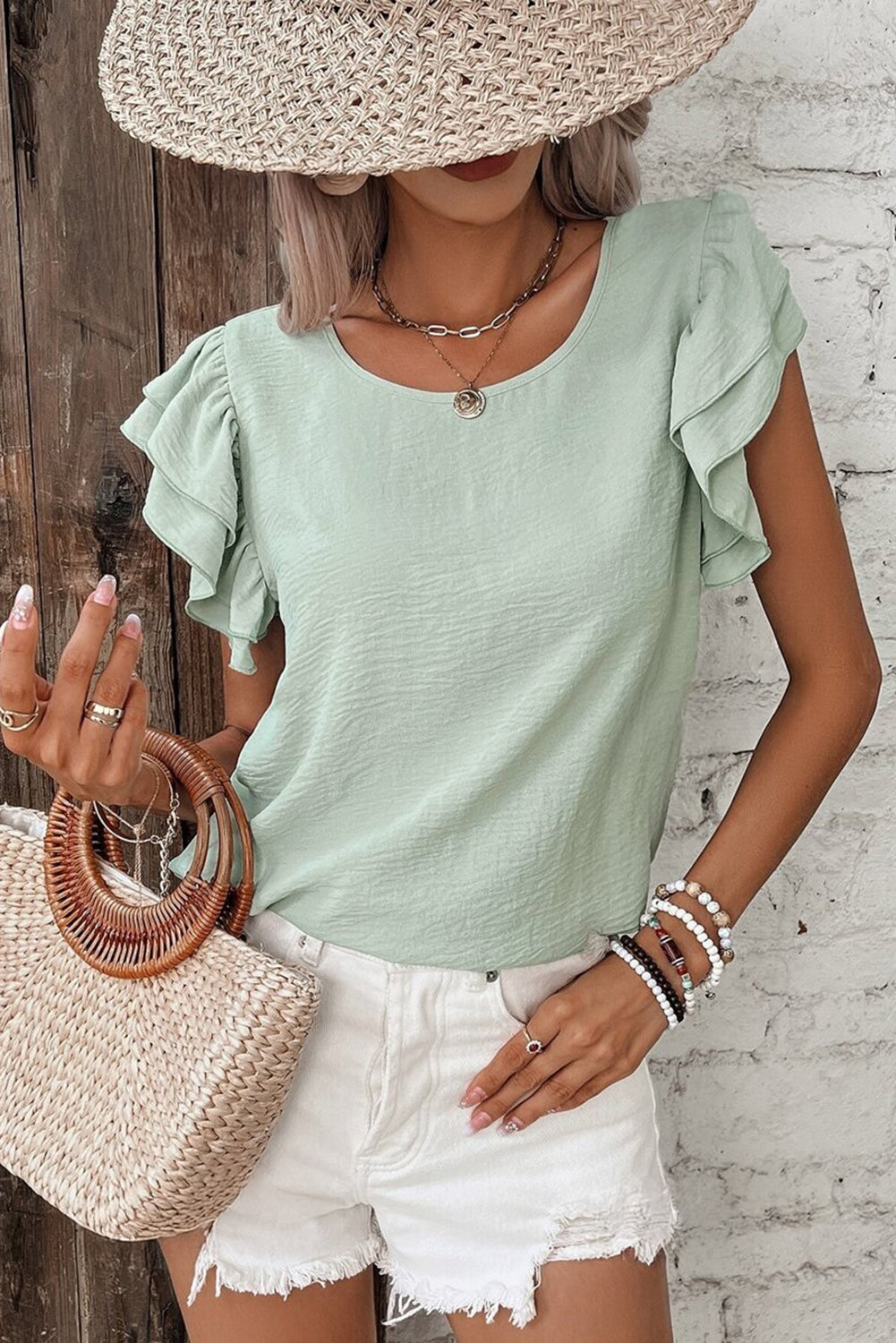 Aqua ruffled blouse paired with white shorts, perfect for casual summer outings.