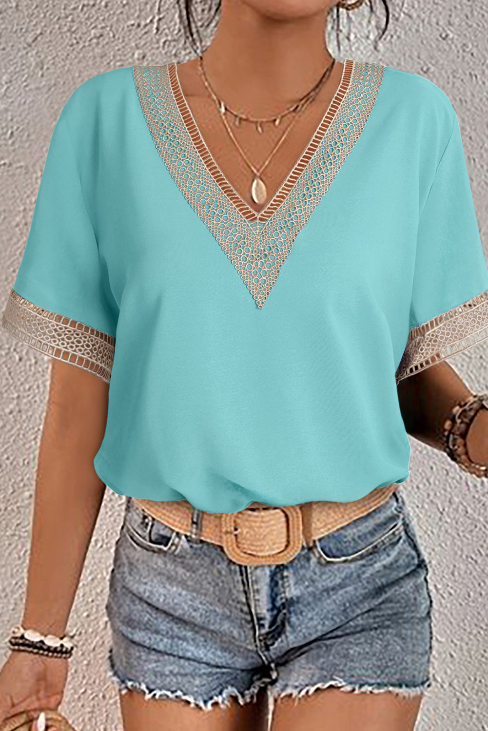 Green V-neck blouse with delicate lace trim and short sleeves
