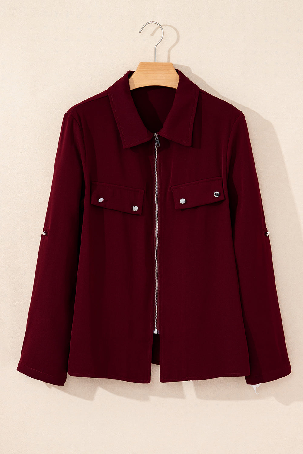 Black jacket with collar, tab sleeves, and zip-up flap detail