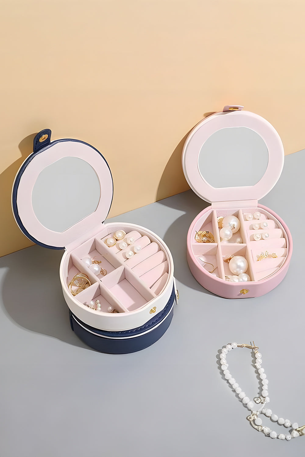 Light pink jewelry organizer case with snap button and built-in mirror in compact round shape