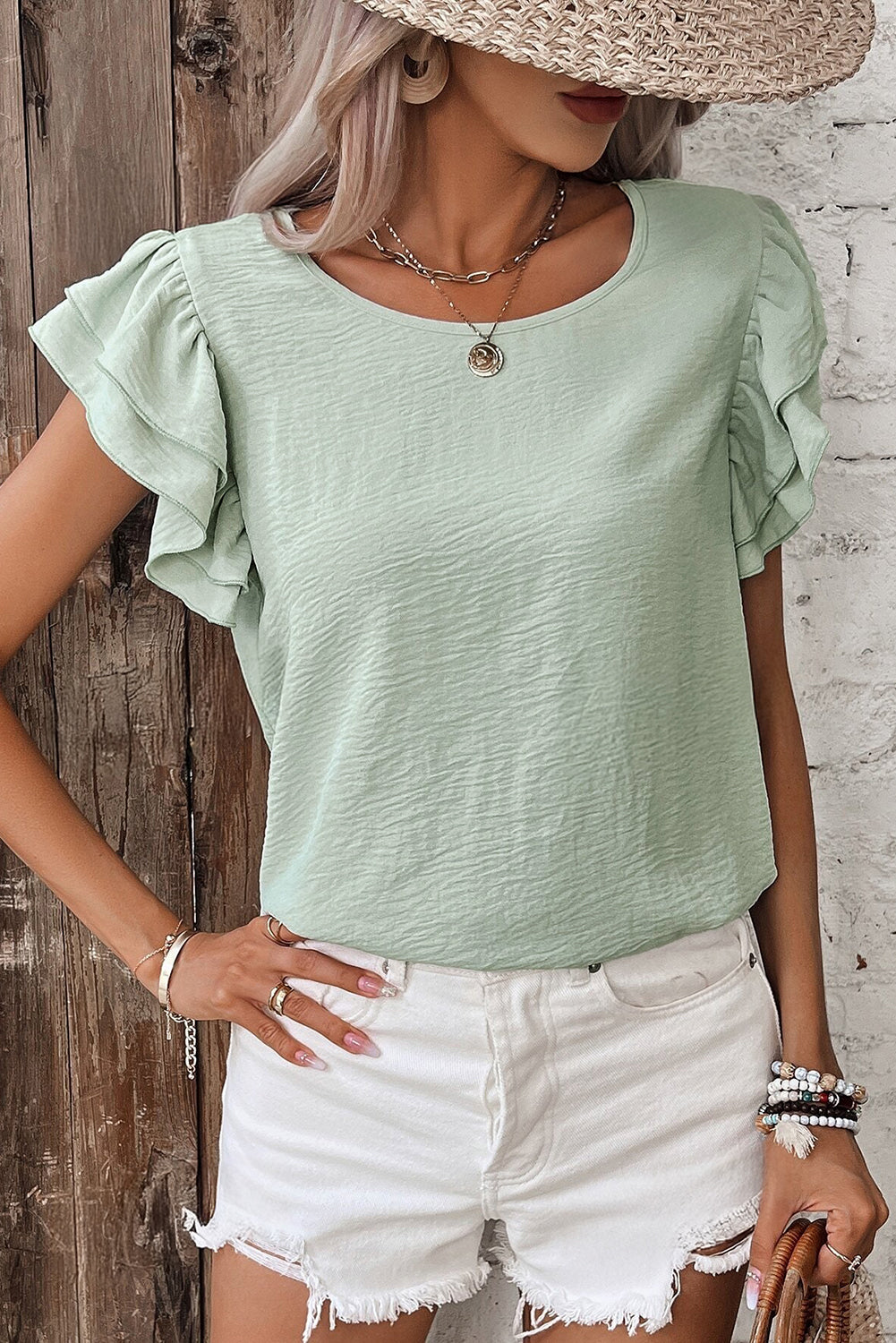 Aqua ruffled blouse paired with white shorts, perfect for casual summer outings.