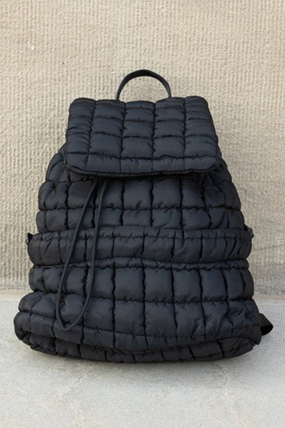 Black solid flapped quilted puffer backpack with spacious interior and modern stylish design