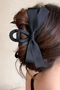 Large black bow decor hair claw clip securing thick hair