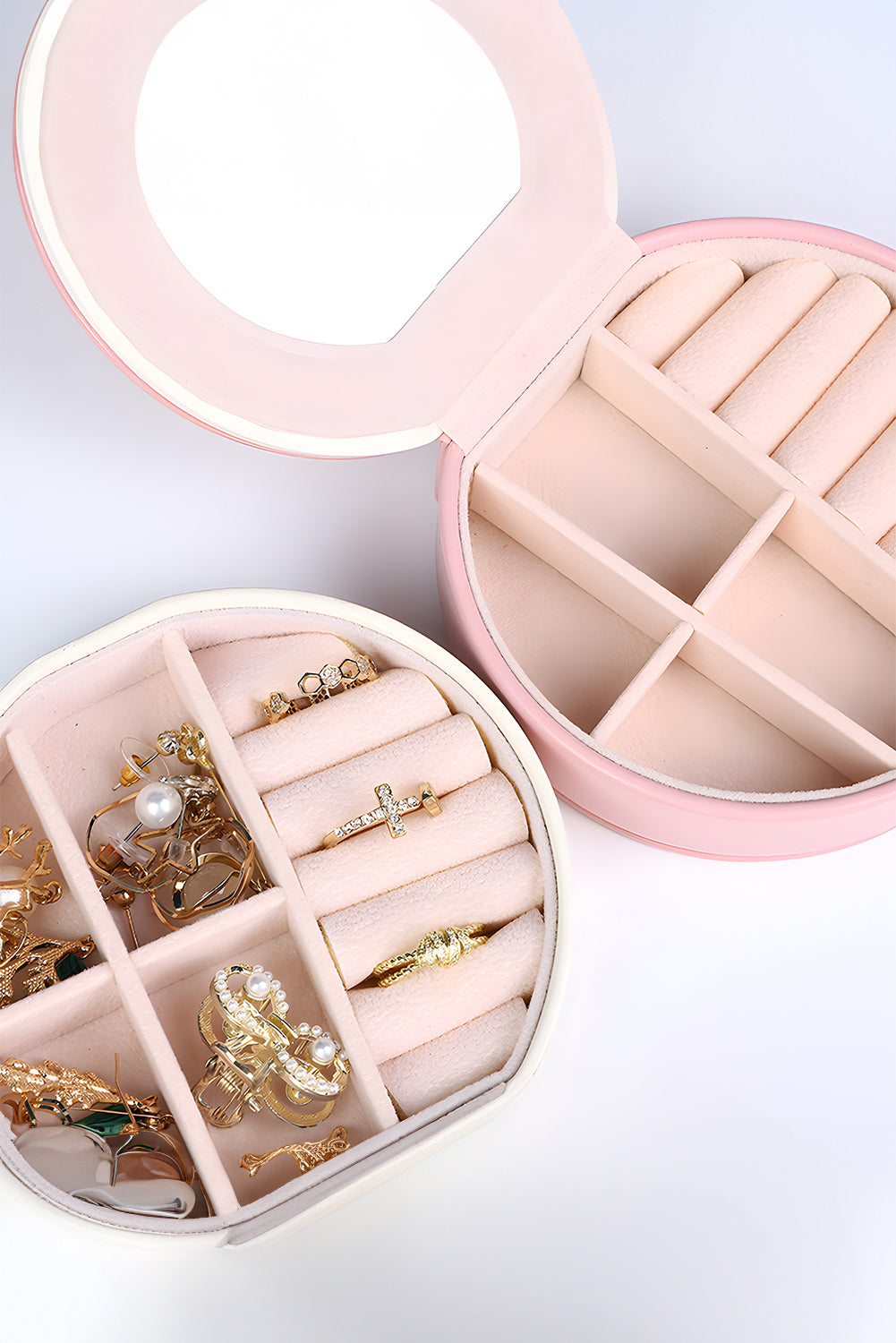 Light pink jewelry organizer cases with mirror and snap button closure in compact round shape