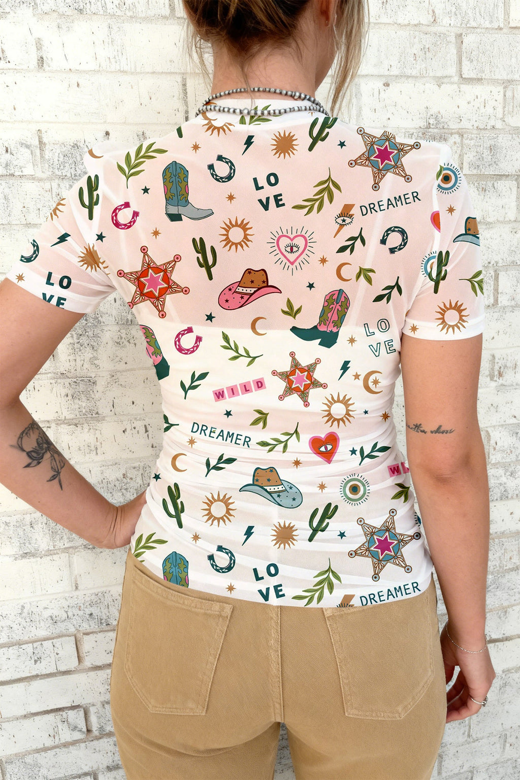 White sheer mesh top with Western print of cowboy boots, stars, and cactus motifs
