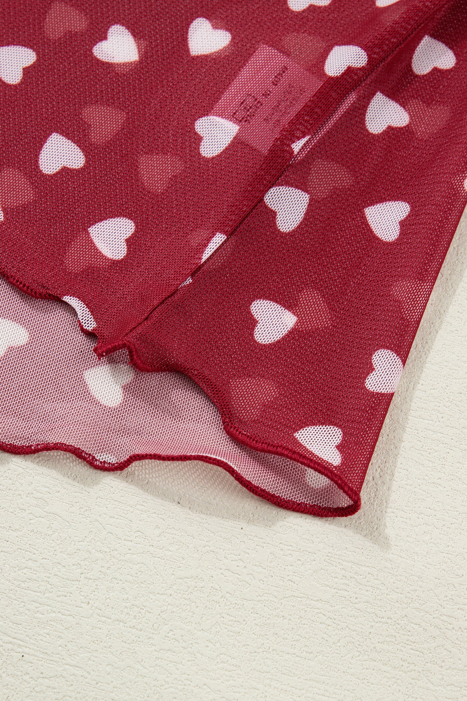 Pink mesh crop top with allover heart print and lettuce trim neckline