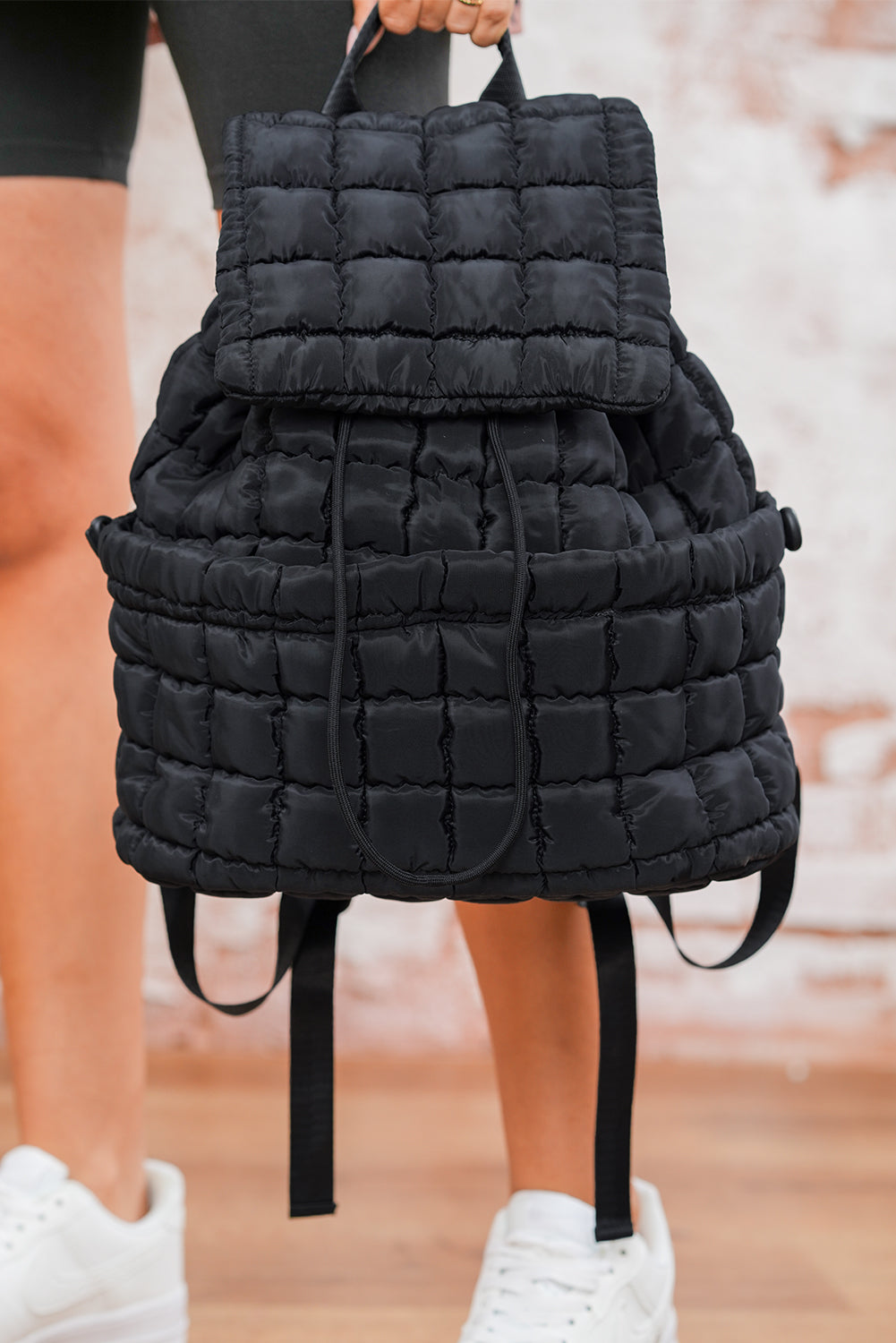 Black solid flapped quilted puffer backpack with spacious interior and modern stylish design