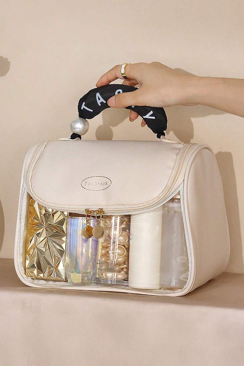 Beige clear makeup bag with TASTY print and handle showing inside pocket storage