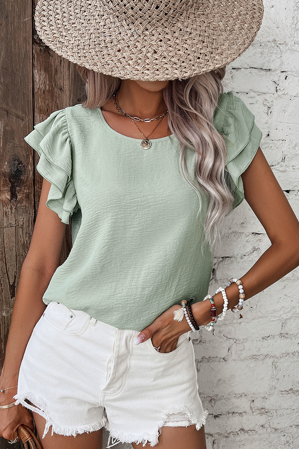 Aqua ruffled blouse paired with white shorts, perfect for casual summer outings.