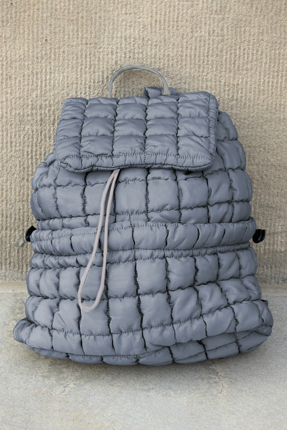 Black solid flapped quilted puffer backpack with spacious interior and modern design